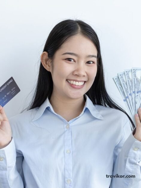 The-image-shows-a-lady-holding-a-travel-card-and-some-dollars